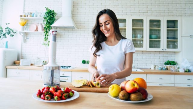 Woman making fruits smoothies with blender