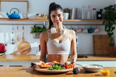 Shot of fintess woman making a healthy poke bowl in the kitchen at home.