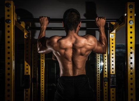 Rear view of healthy muscular young man with his arms stretched out, Strong athletic man fitness model torso showing six pack abs, Muscular athletic bodybuilder fitness model