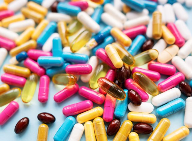 Lots of colorful pills and capsules for different symptoms. Selective focus, noise. Concept of health and medicine