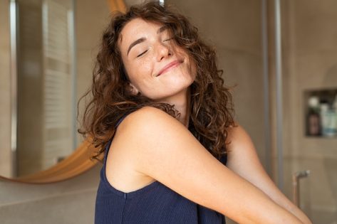 Smiling woman stretching with hands forward feeling fresh on a bright morning.