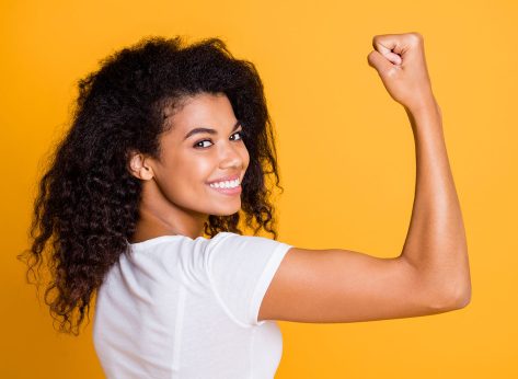Close-up profile side view portrait of her she nice attractive lovely brunet cheerful wavy-haired girl showing strong muscles isolated over bright vivid shine vibrant yellow color background