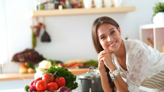 Young woman using a tablet computer to cook in her kitchen