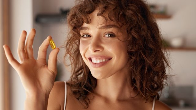 Happy Smiling Woman Holding Pill