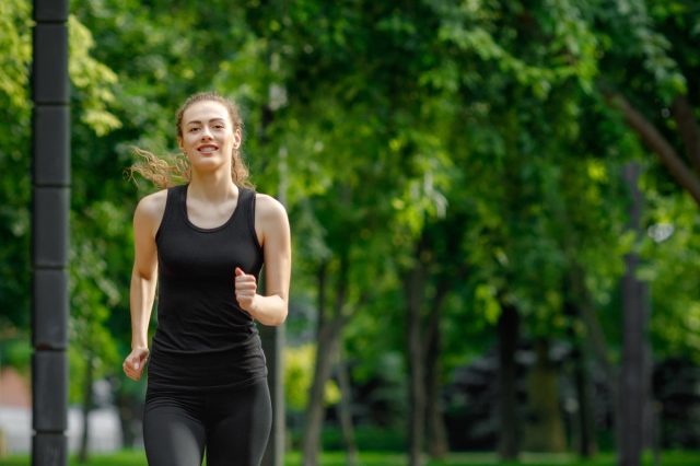 young attractive woman running in summer park