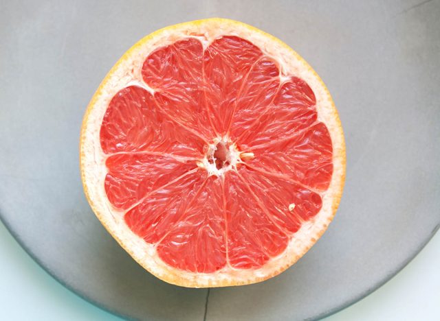 Ripe grapefruit half on grey concrete plate from a high angle view close up
