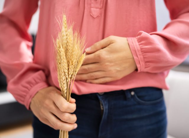 Celiac Disease And Gluten Intolerance. Women Holding Spikelet Of Wheat
