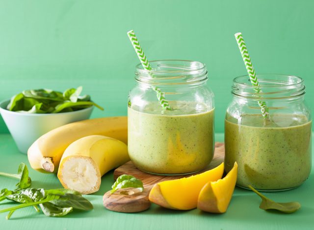 healthy green smoothie with spinach mango banana in glass jars