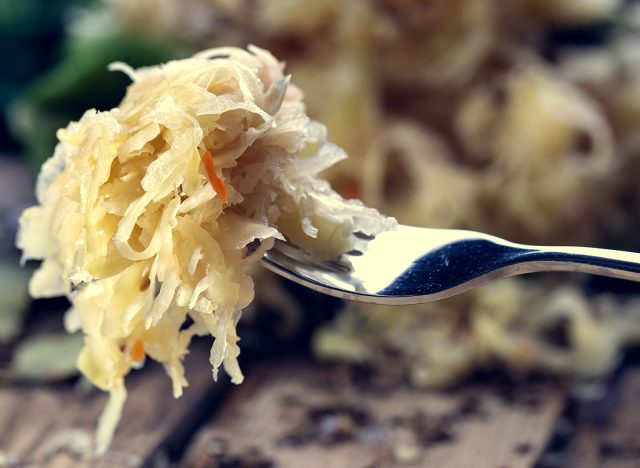 Sauerkraut on a fork with a shallow depth of field. Pickling cabbage at home. The best natural probiotic.