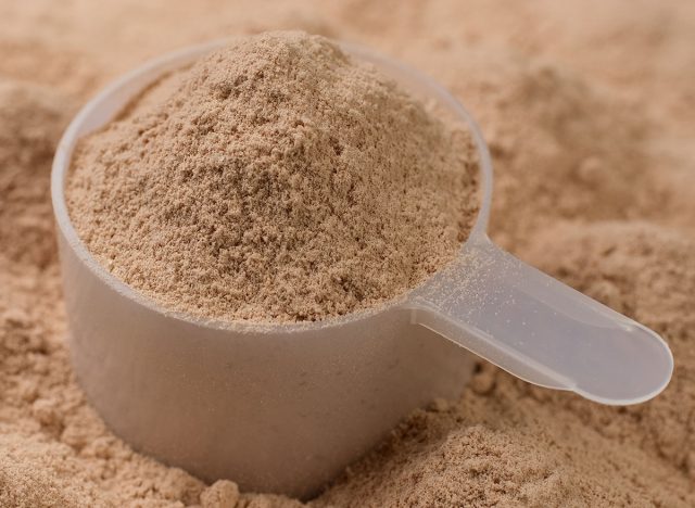 Chocolate colour protein, whey powder sprinkle in cup. Bodybuilding, fitness and gym lifestyle