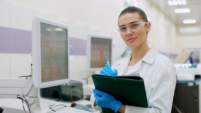 A female scientist controls the operation of devices for laboratory research. Modern laboratory technologies