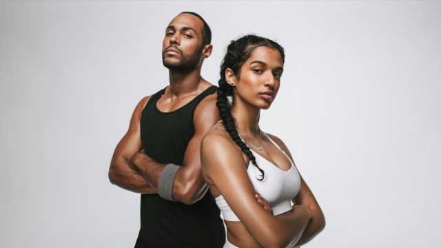 Close up of male and female athlete standing with arms crossed.