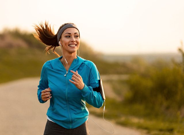 Dedicated athletic woman running in nature and dawn.