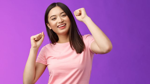 Joyful glamour asian attractive girl having fun enjoy awesome party feeling carefree, fist pump during dance, smiling broadly like good music, attend concert, stand purple background