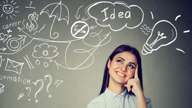 Portrait of a woman thinking dreaming has many ideas looking up at plan isolated on gray wall background. Decision making concept