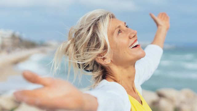 Joyful,Woman,Enjoying,The,Freedom,Of,The,Beach,Standing,With