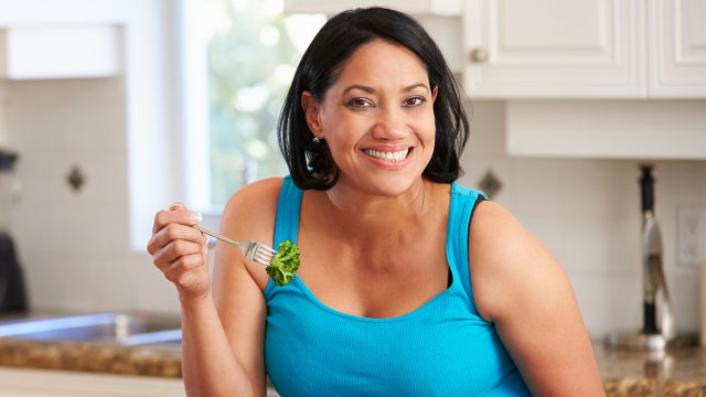 Overweight,Woman,Eating,Healthy,Meal,In,Kitchen