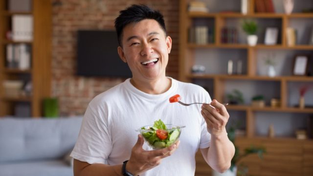 Happy,Asian,Mature,Man,Holding,Fork,And,Bowl,With,Fresh
