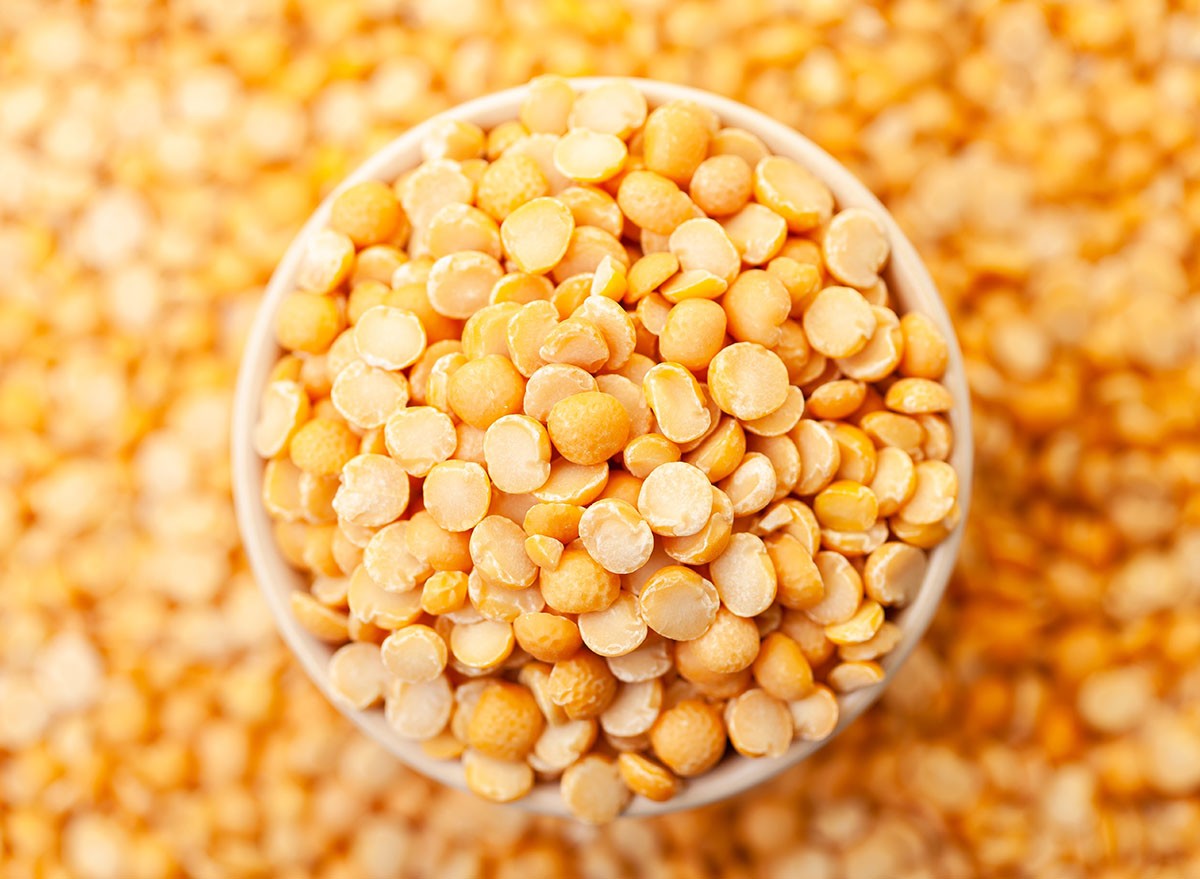Uncooked, split, yellow peas in bowl. Dry peas grains. Top view