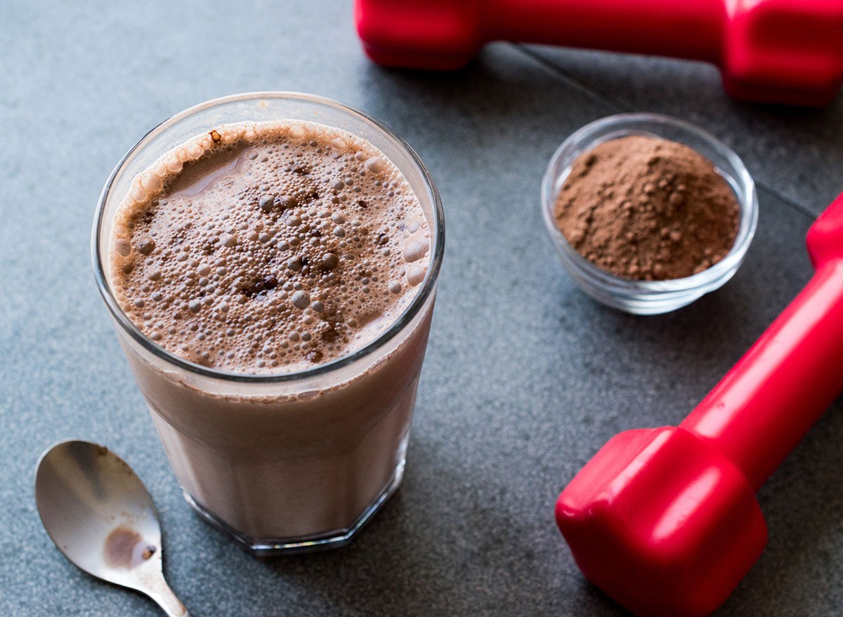 Chocolate Protein Shake Smoothie with Whey Protein Powder and Red Dumbbells. Sports Drink