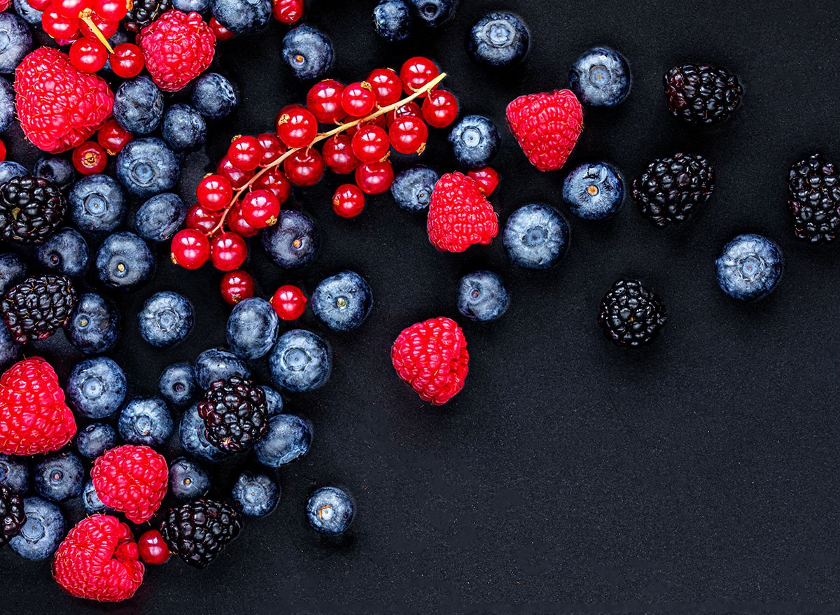 Various fresh forest berries on black stone background, top view. Berry mix. Flat lay. blueberries, raspberry, raspberries, blackberries, berry