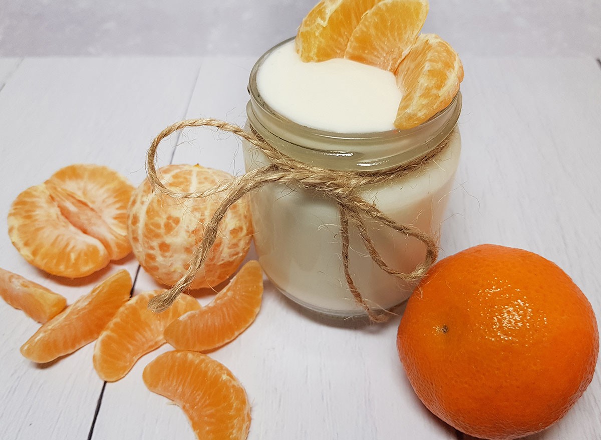 Homemade yogurt in a glass jar with purified and uncleaned mandarins.