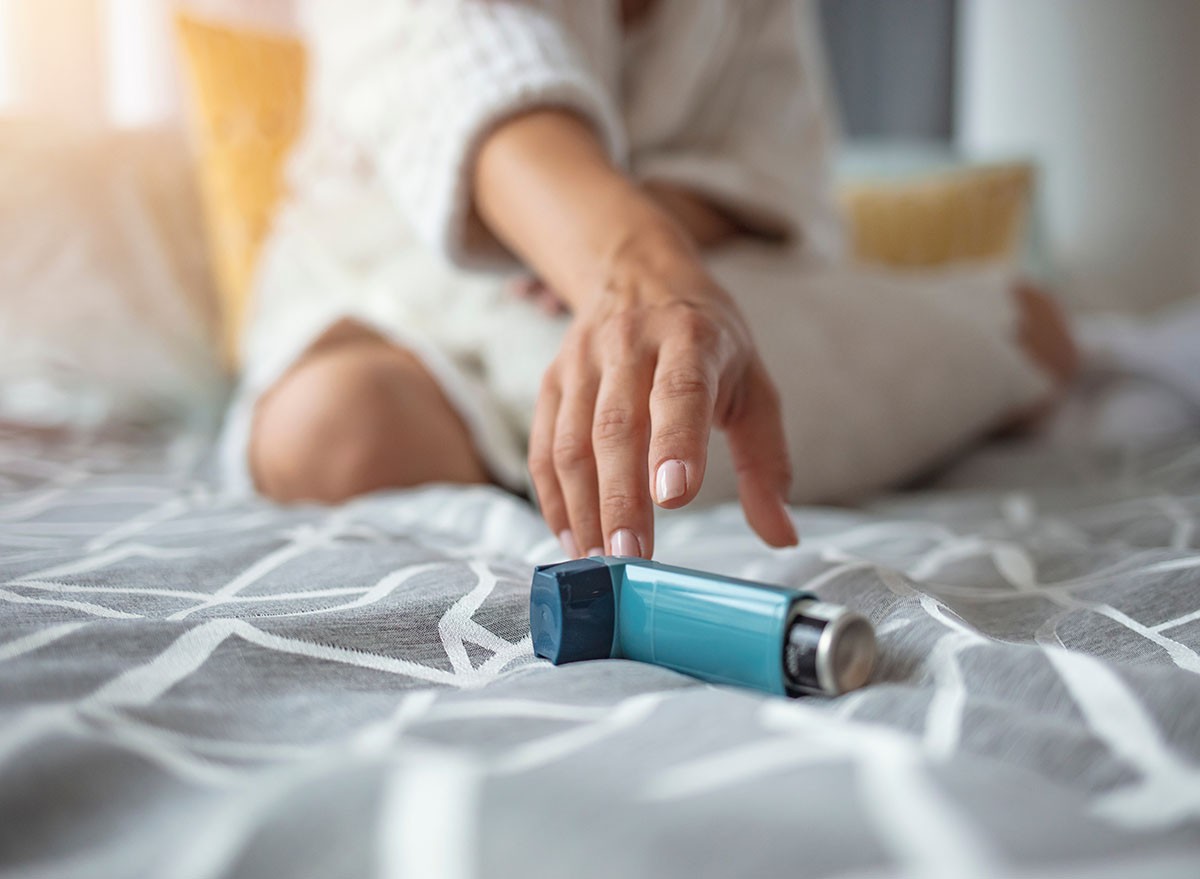 Asmathic girl catching inhaler having an asthma attack. Young woman having asthma attack. She is holding inhaler. Asthmatic woman using an asthma inhaler during asthma attacks