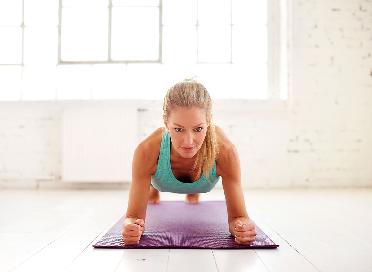 Sphinx Push-Ups, Portrait shot of attractive middle aged woman doing plank exercises on yoga mat in the fitness studio.