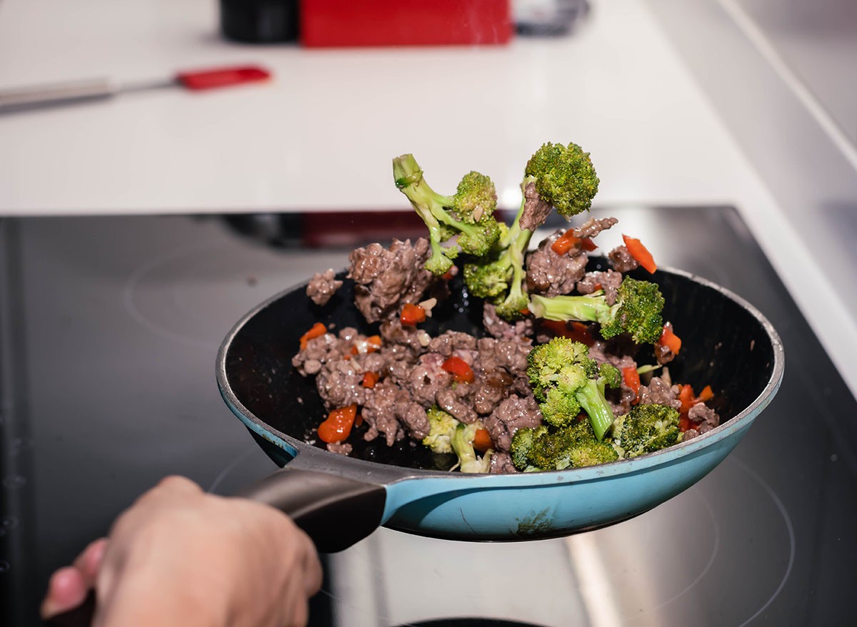 Skillet of ground beef stir fry with vegetables broccoli pepper and onion on an electric stove on high speed Cordoba Argentina
