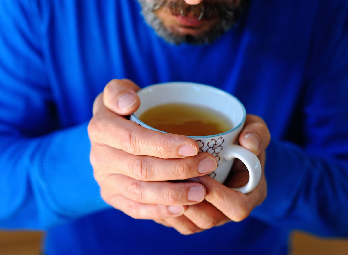 White man drinking green tea from porcelain cup