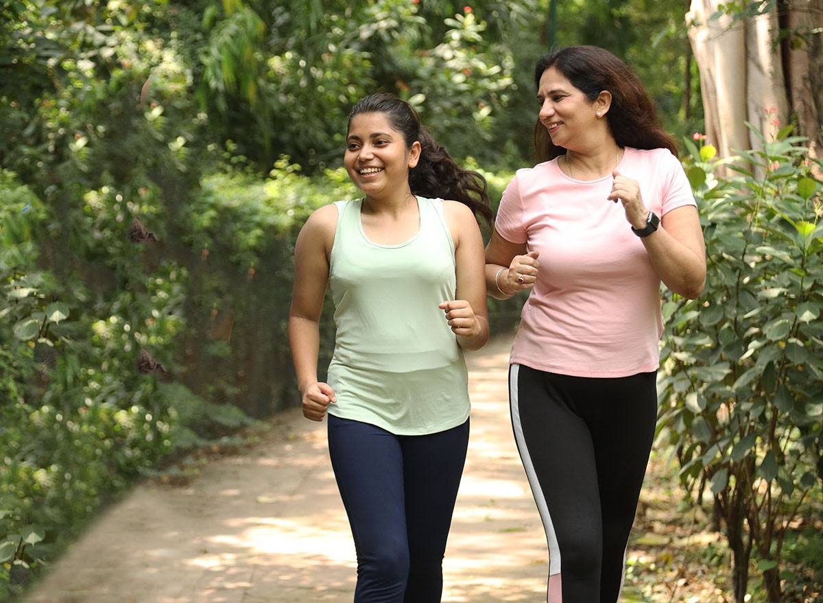 Indian mother and daughter running at park