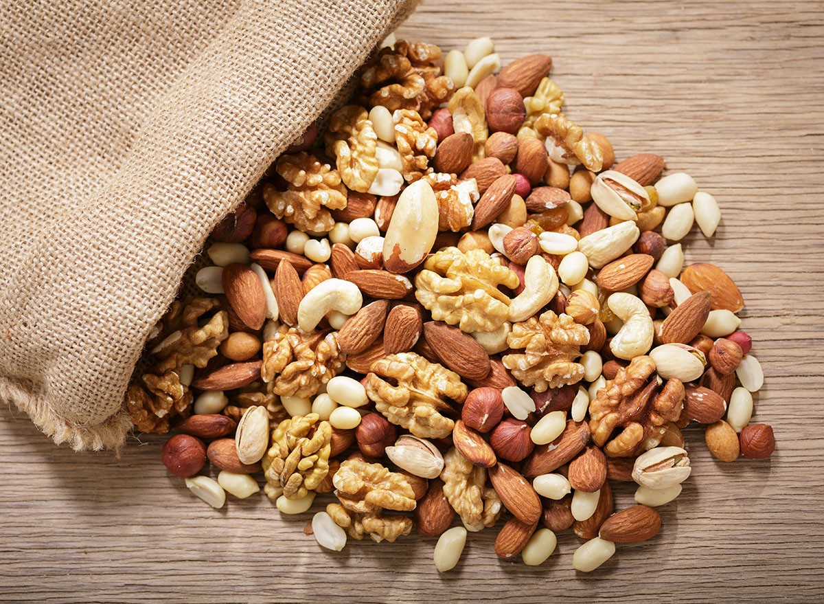 close up of sack of mixed nuts on wooden table, top view