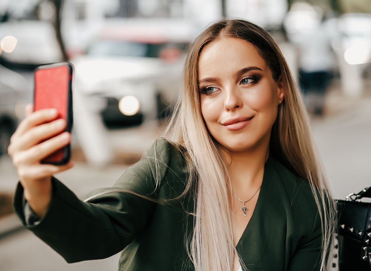 Cute and pretty fashion trendy business woman or girl makes selfie on smartphone camera to share on internet social media iphone, cell phone