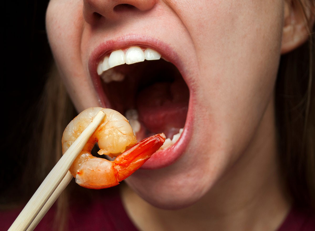 Woman,Eating,Grilled,Shrimp,With,Chopsticks.,Asian,Cuisine.,Wide,Open