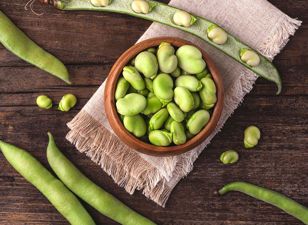 Broad bean or fava beans (Fave) on the rustic wooden background, close-up. From garden to table: springtime vegetables and legumes for spring recipes