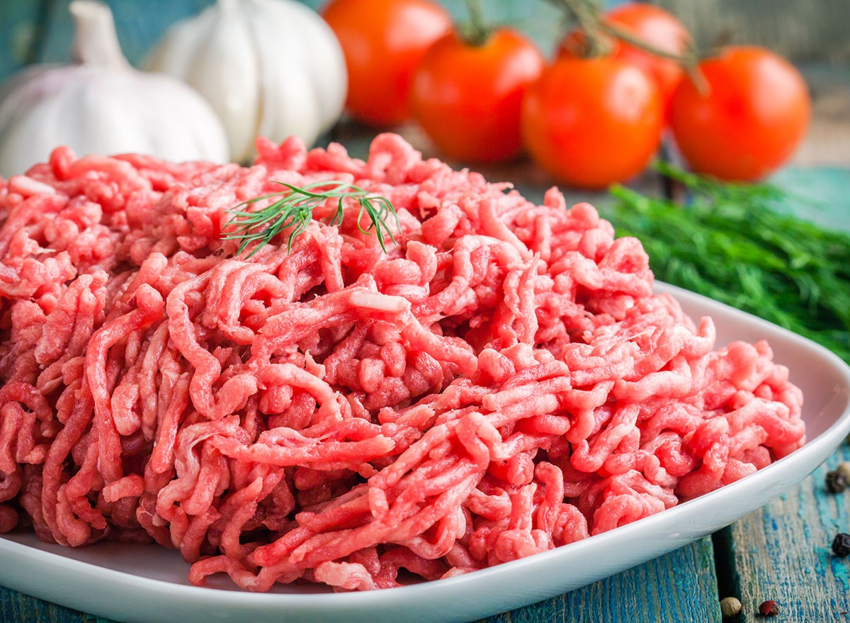 fresh raw minced beef in a plate close up on a rustic wooden table