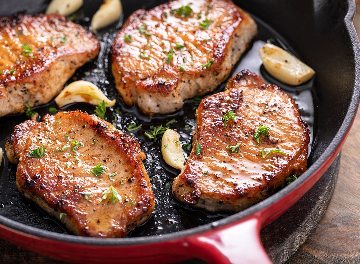 Pork,Chops,Cooked,With,Garlic,In,A,Cast,Iron,Pan