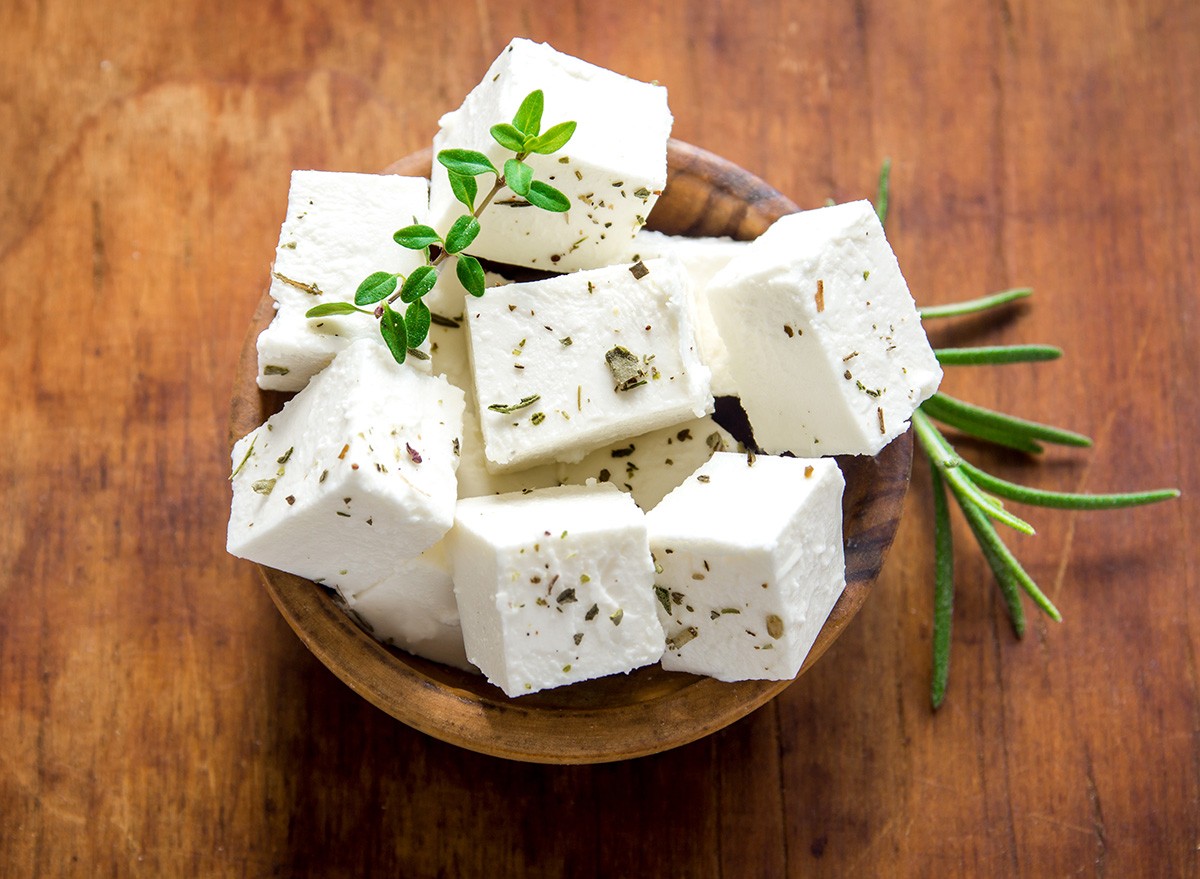 Fresh Greek Feta Cheese. Healthy ingredient for cooking salad. Chopped Goat feta cheese with herbs.