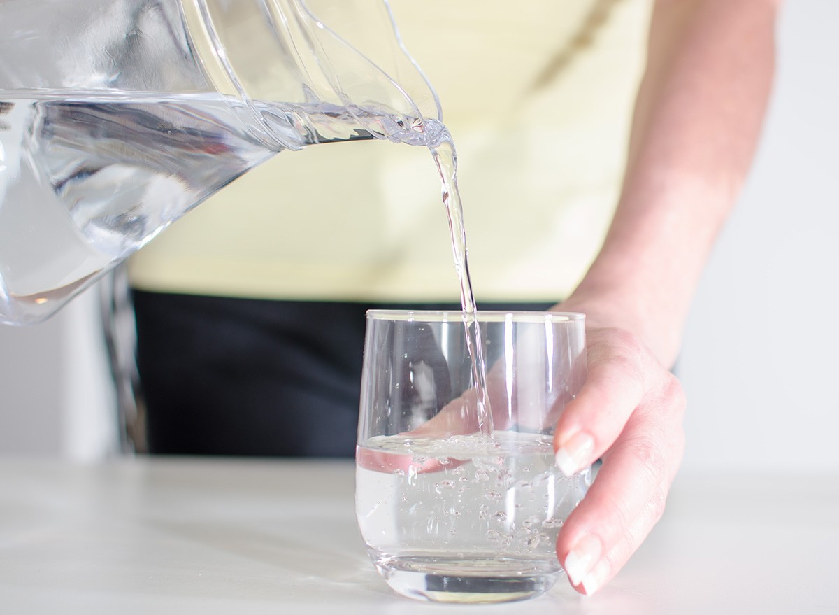 Woman pouring water from a jug into a glass
