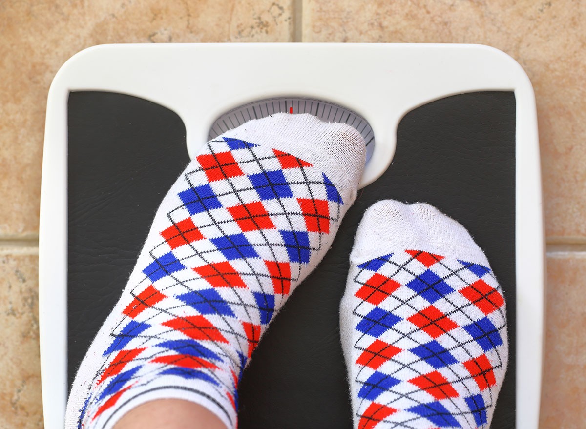 Woman's feet on bathroom scale. Diet concept. Scales, weigh